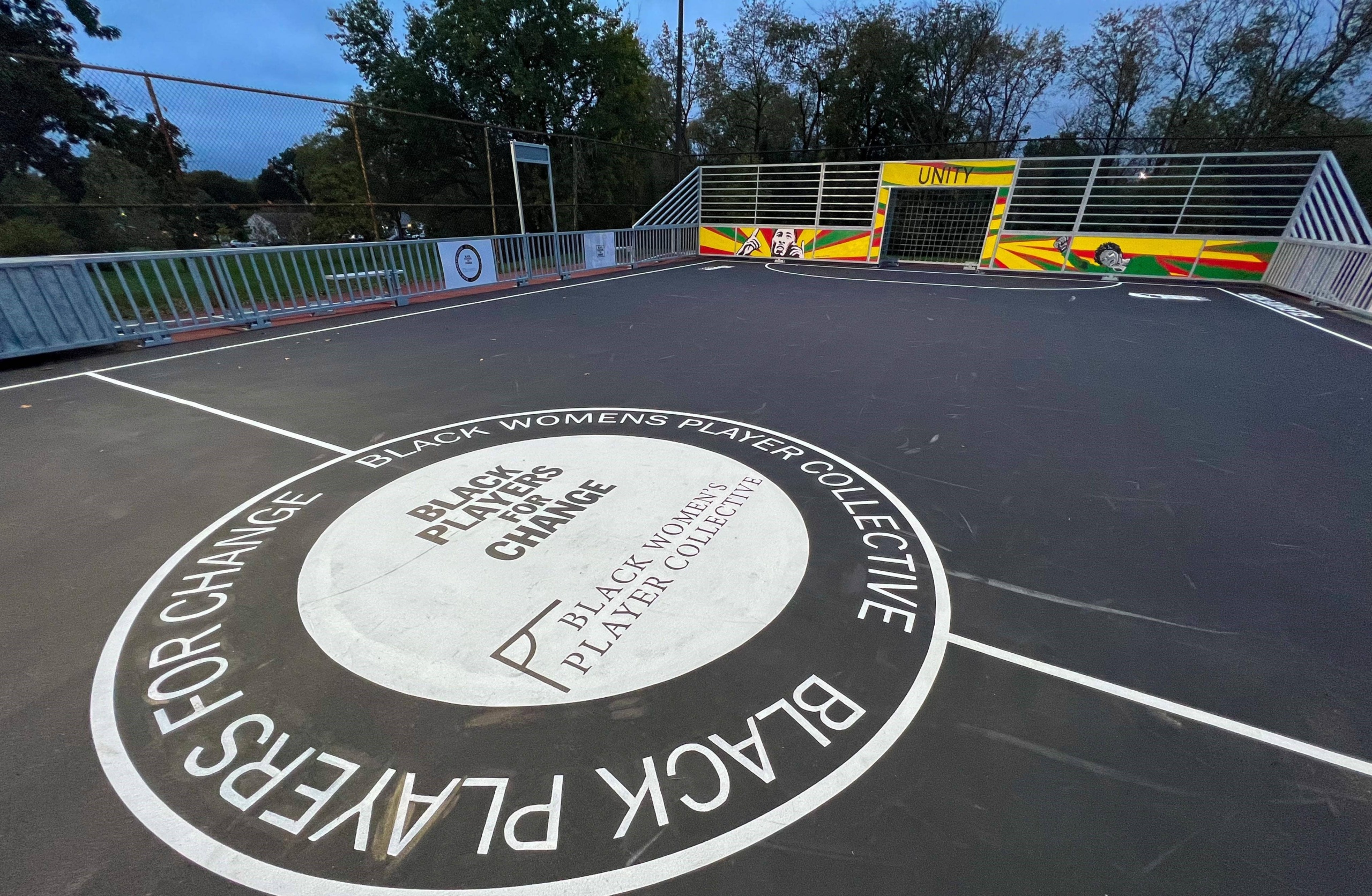Black mini-pitch with custom mural around the goal and side boards