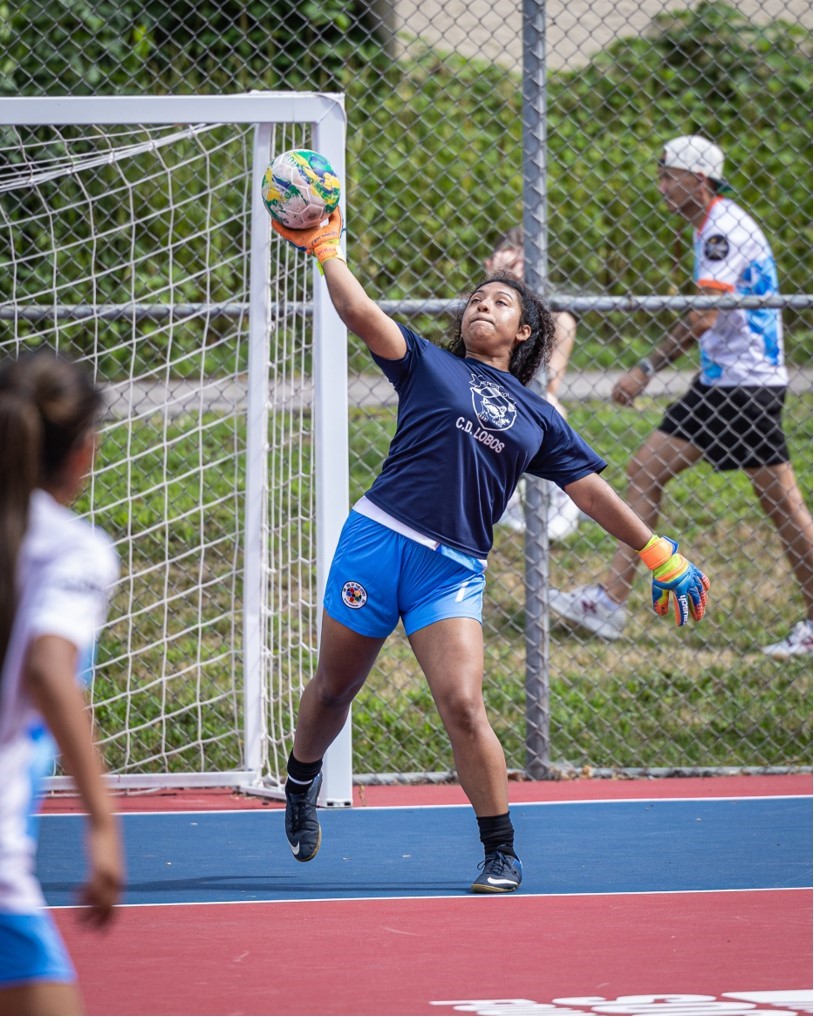 a girl goalie throws the ball out to her teammates