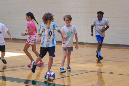 Kids playing soccer in the gym