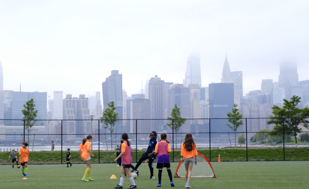 Coach Yanique playing soccer in NY with girls