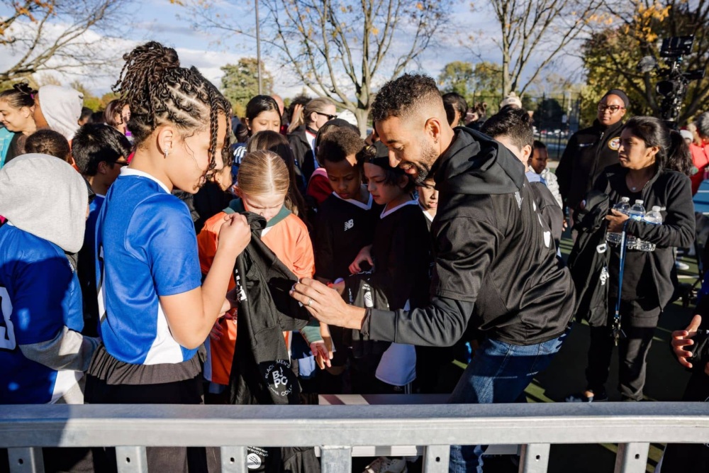 Justin Morrow signs Black Players Collective shirt for a young fan