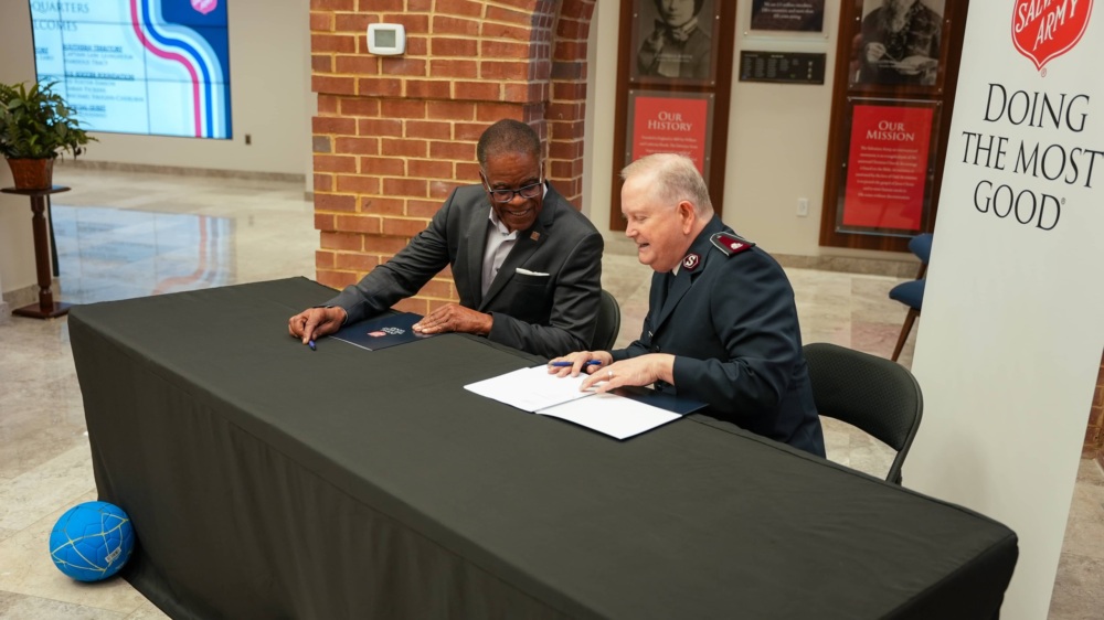 Leaders of the U.S. Soccer Foundation and The Salvation Army look at memorandum of understanding