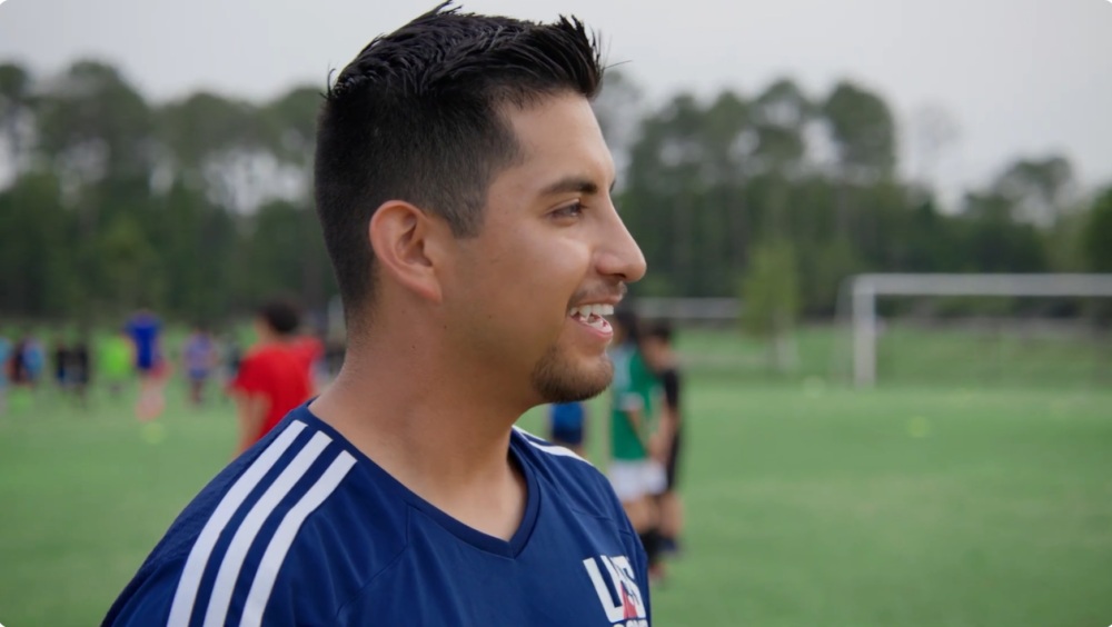 Soccer for Success coach-mentor Adrian looks out at the pitch.