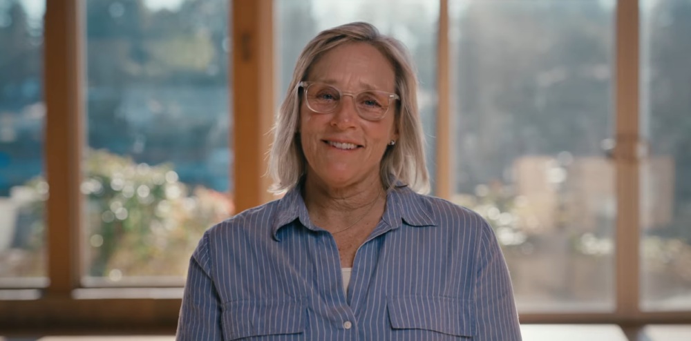 Woman wearing glasses in a blue shirt smiling