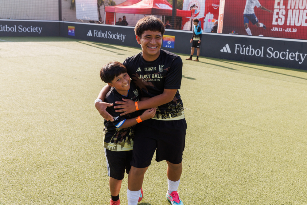Two Boys hug on mini-pitch at the 2025 LA Unity Cup
