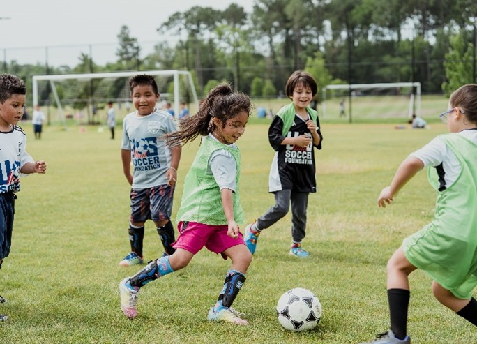 Girl kicking soccer ball in game