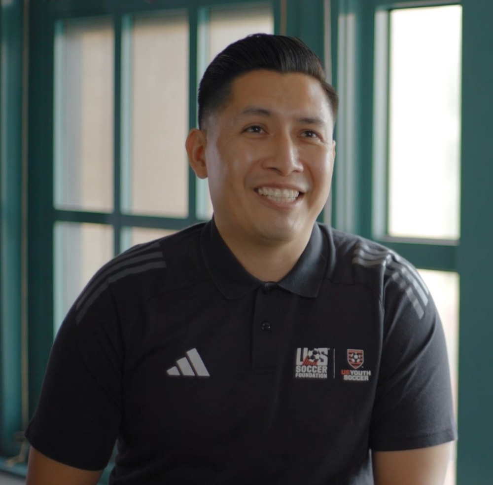 Coach Reyes sits in front of a window